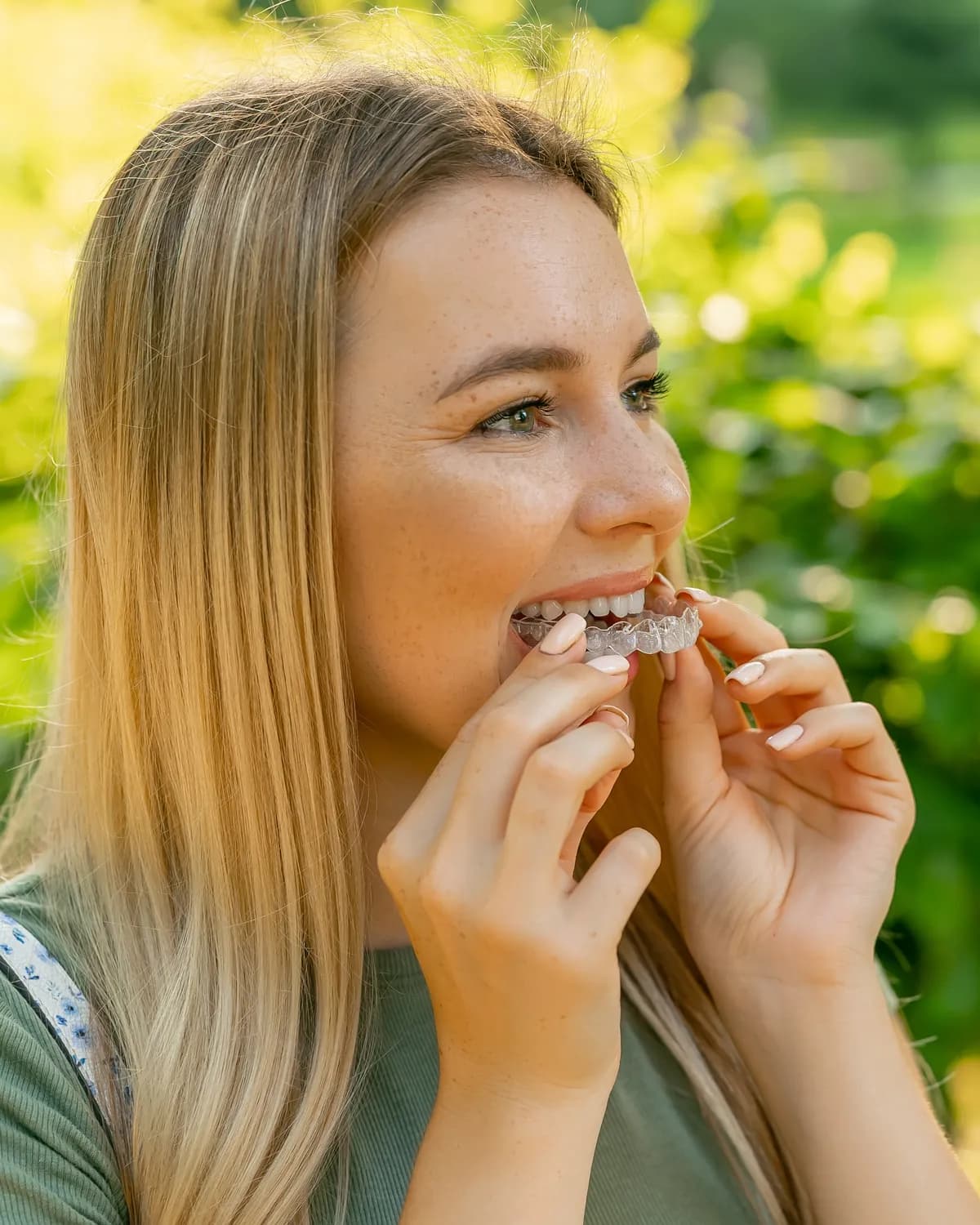 A smiling woman outdoors in warm sunlight
